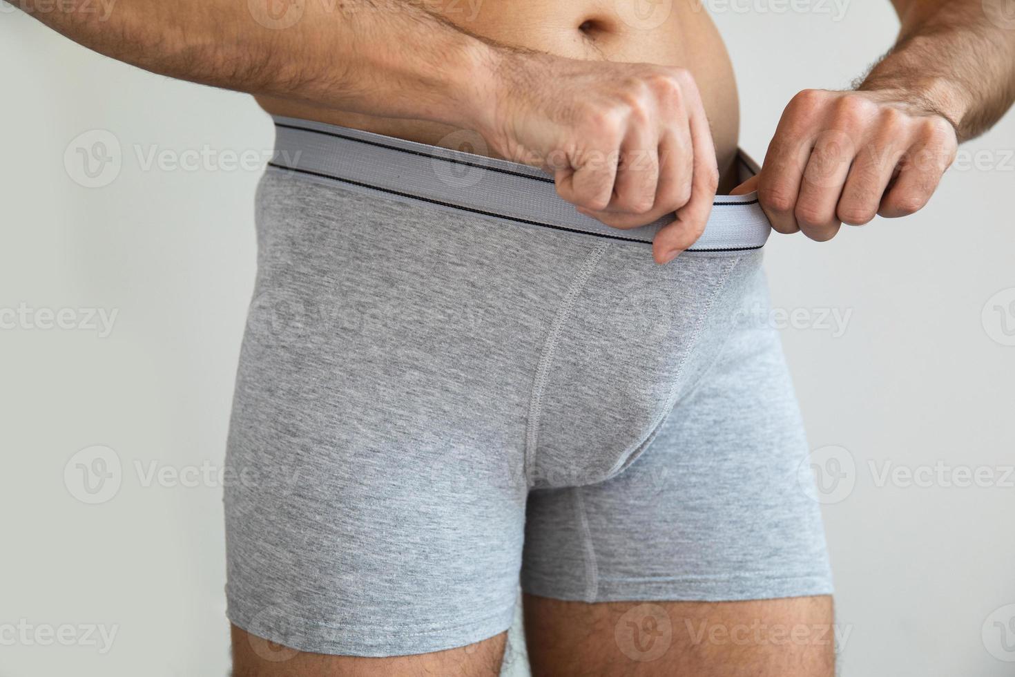 jovem está olhando para sua cueca foto