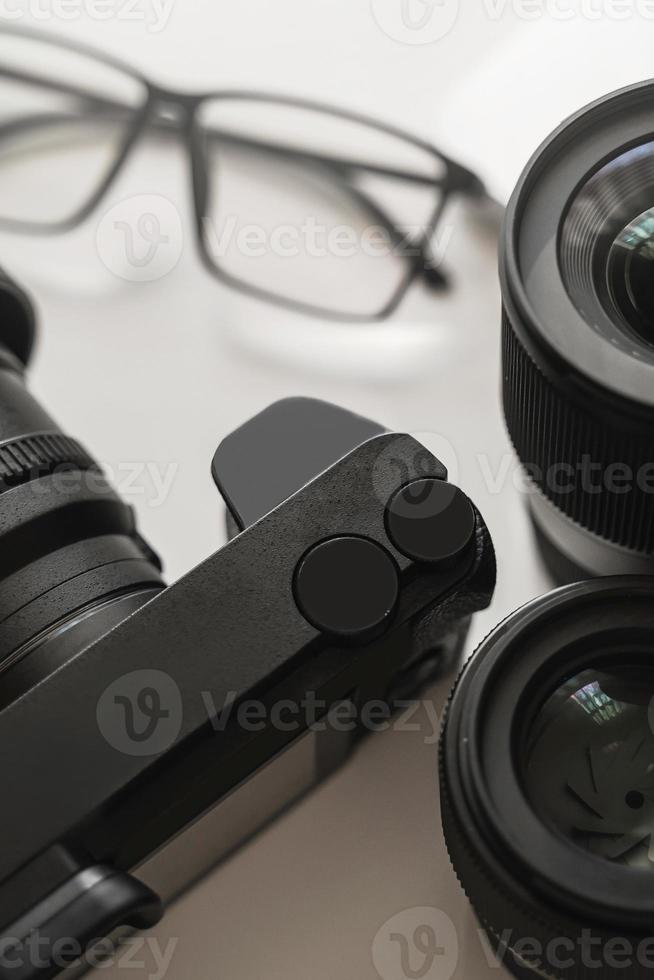 local de trabalho com um equipamento moderno para fotografia. câmera mirrorles e lentes prime. foto