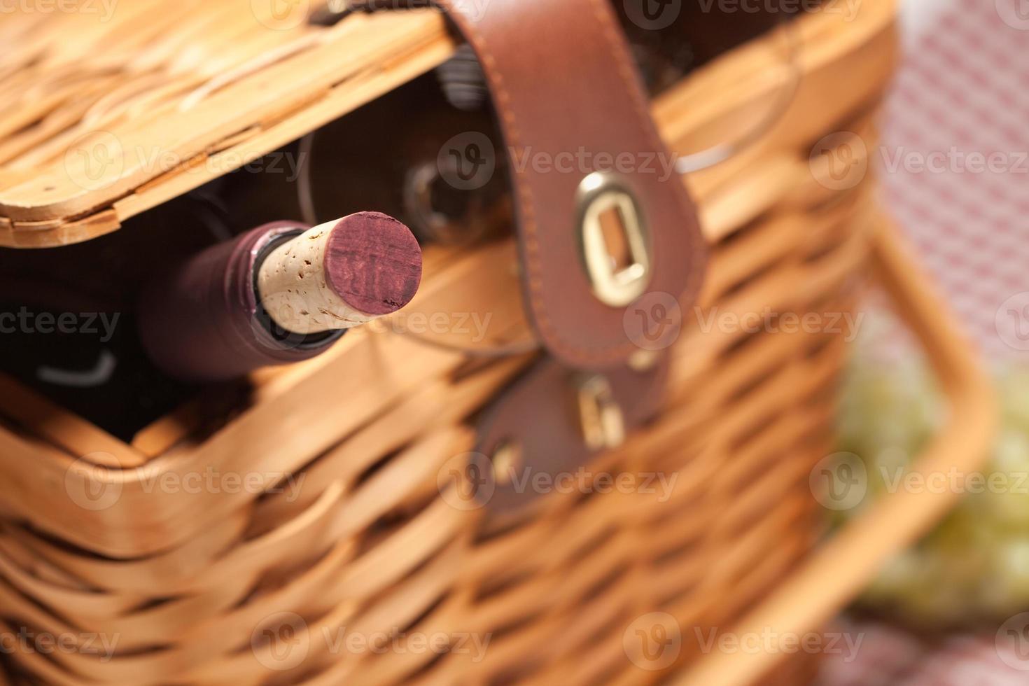 cesta de piquenique, garrafa de vinho e copos vazios foto