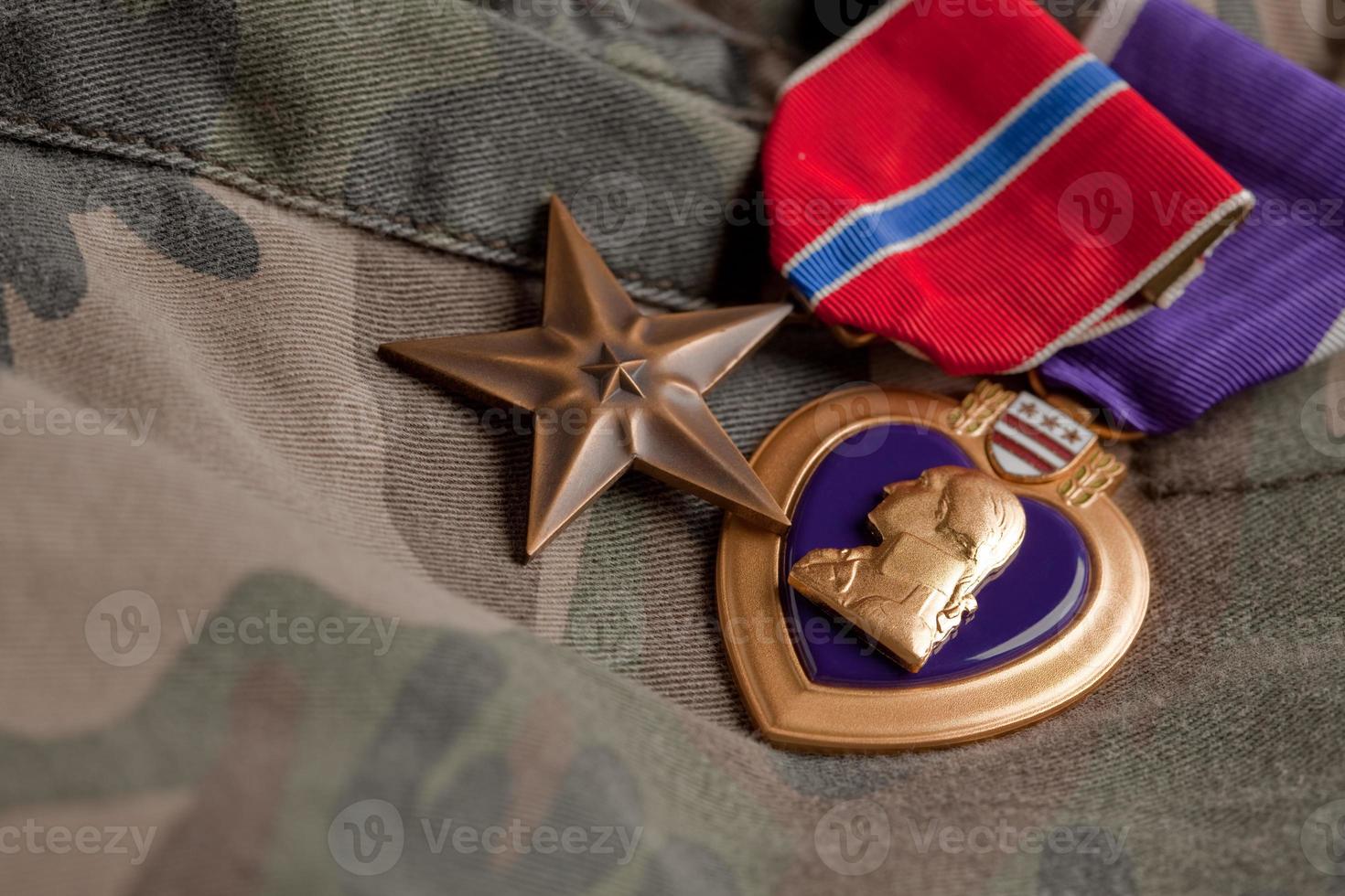 medalhas de bronze e coração roxo em material de camuflagem foto