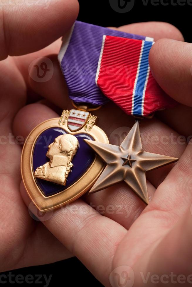 homem segurando medalhas de guerra de coração roxo e bronze foto