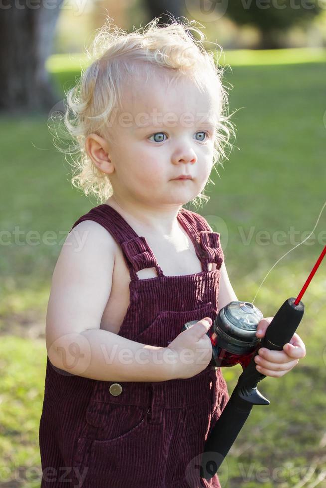 menino bonito com vara de pescar no lago foto