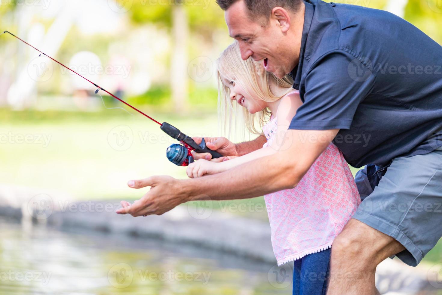 jovem caucasiano pai e filha se divertindo pescando no lago foto