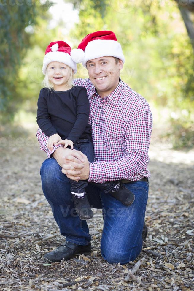 retrato de pai e filha usando gorro de Papai Noel foto