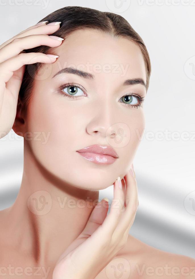 linda garota asiática com pele fresca limpa, fundo cinza abstrato foto