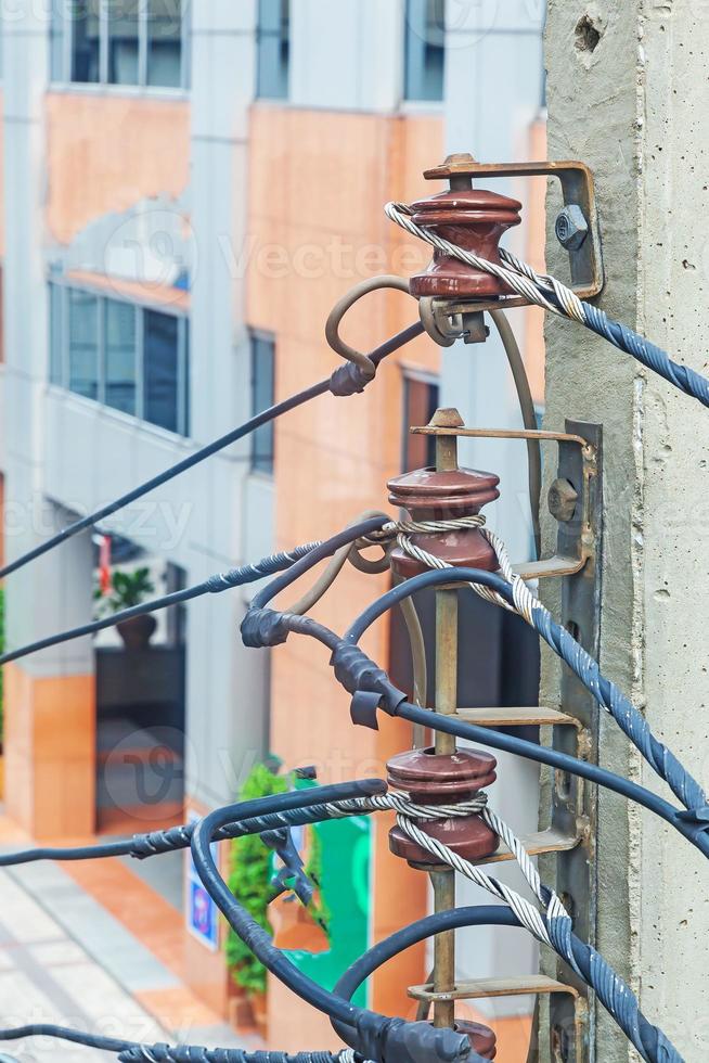 roteamento caótico de cabos elétricos e telefônicos em uma rua principal de bangkok foto