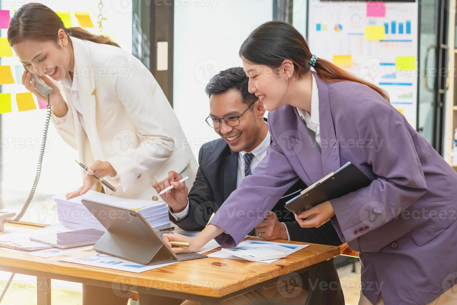 equipe de empresários asiáticos ajudando a debater ideias de gerenciamento para a empresa está expressando alegria e felicidade que a empresa alcançou sucesso comercial. foto