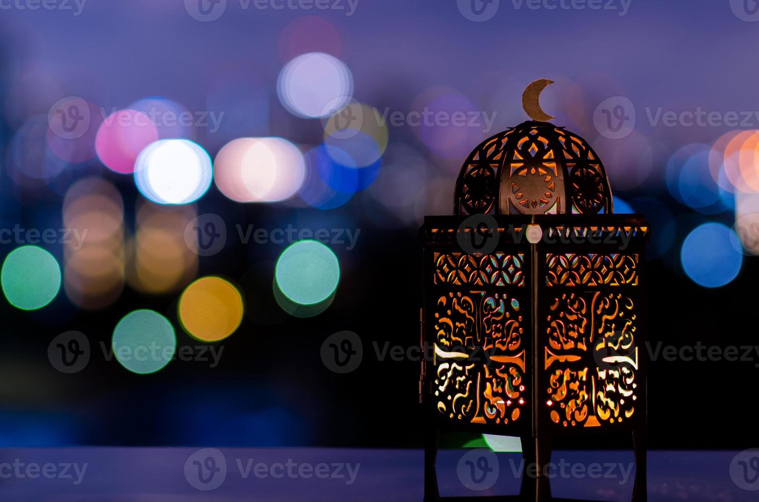 lanterna com céu noturno e cidade bokeh luz de fundo para a festa muçulmana do mês sagrado do ramadã kareem. foto