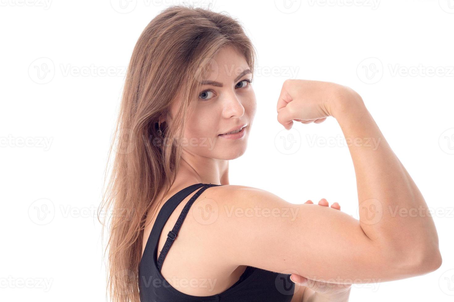 a menina dos esportes mostra o músculo na mão closeup foto