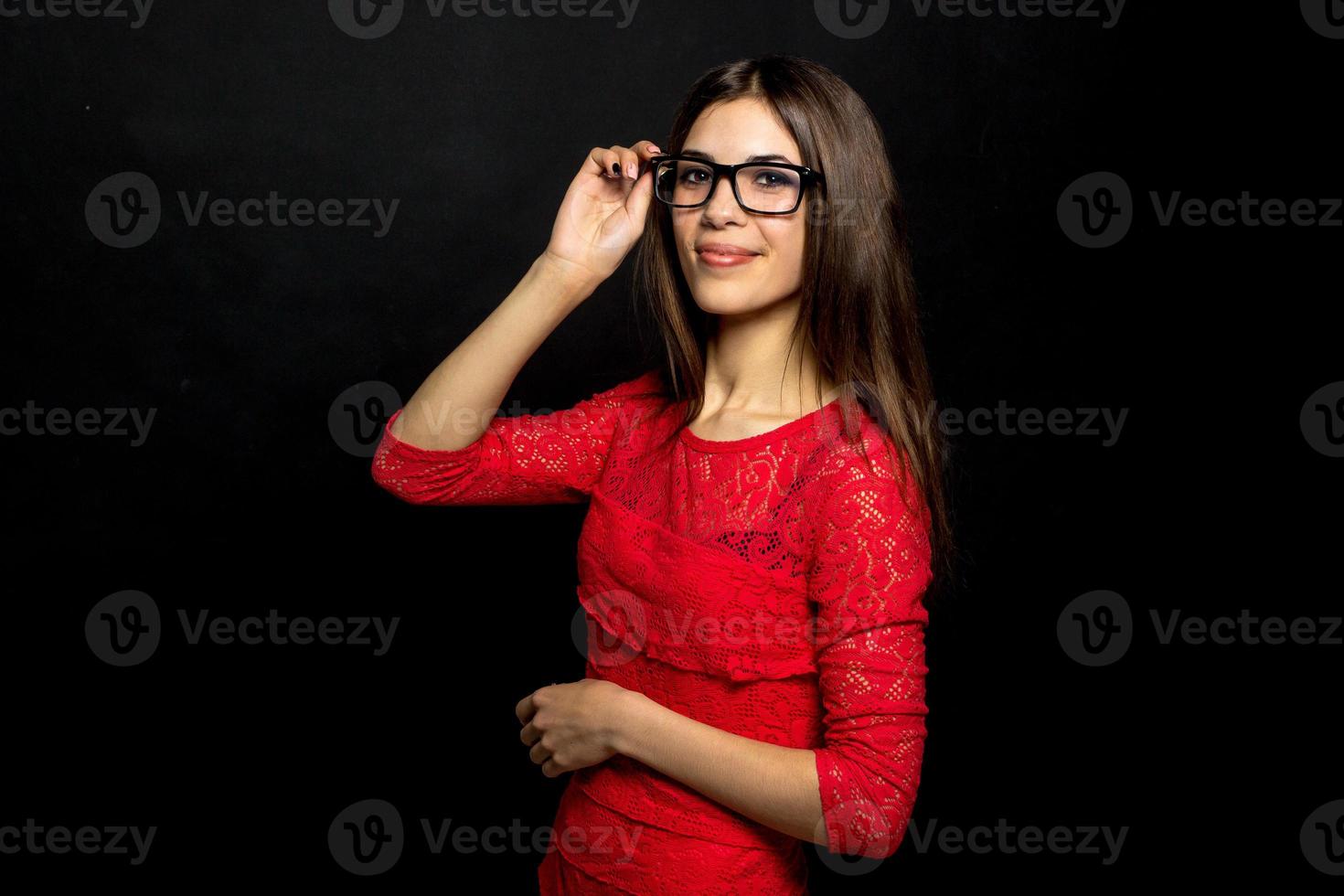 mulher de óculos e vestido vermelho olhando para a câmera foto