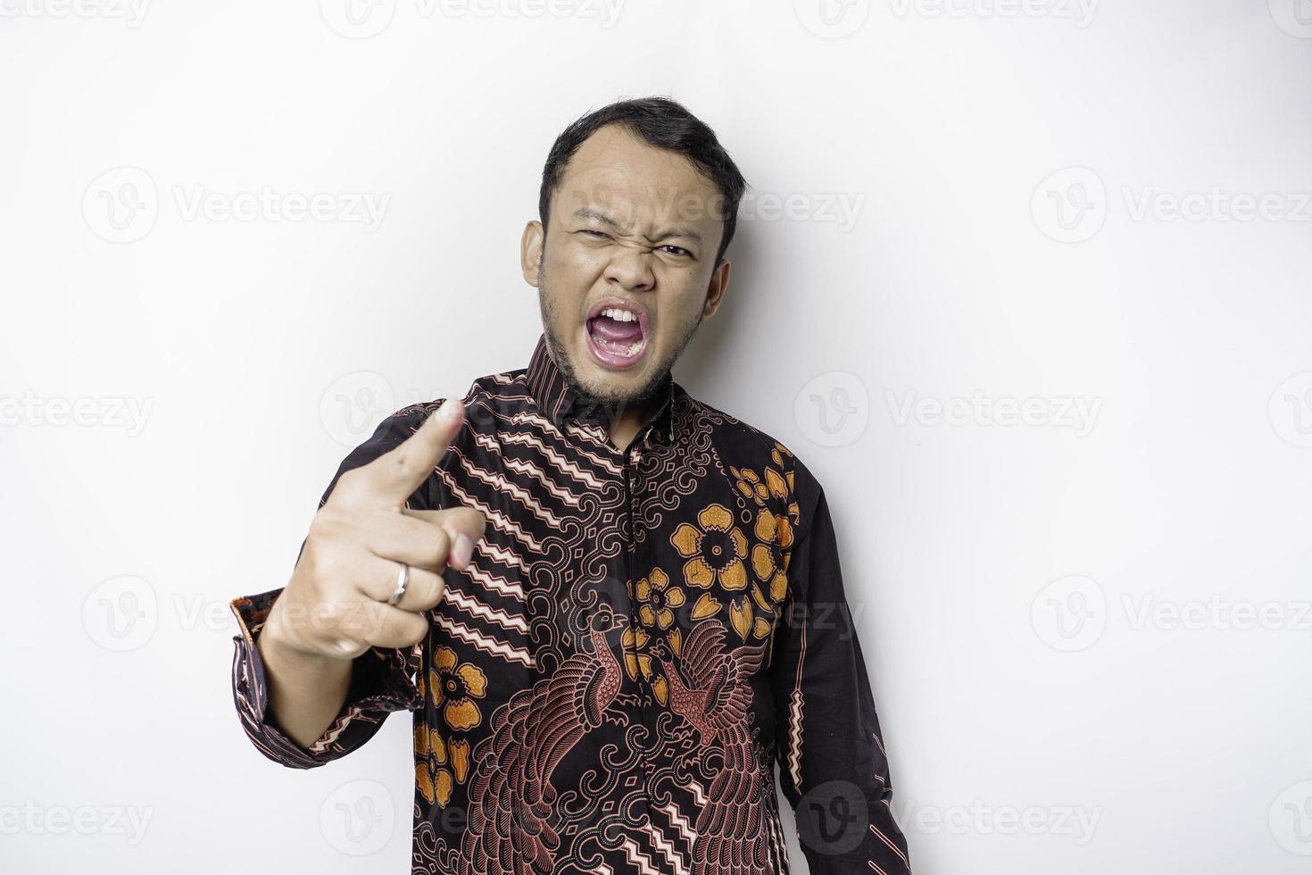 o rosto zangado e louco do homem asiático em fundo branco isolado de camisa batik. foto