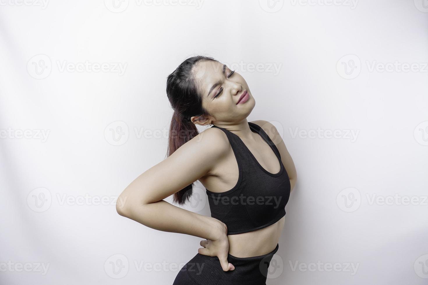 mulher asiática esportiva chateada cansada vestindo roupas esportivas está sofrendo de dor nas costas, espasmo muscular no local de trabalho. cansaço, prazo, dor e postura incorreta foto