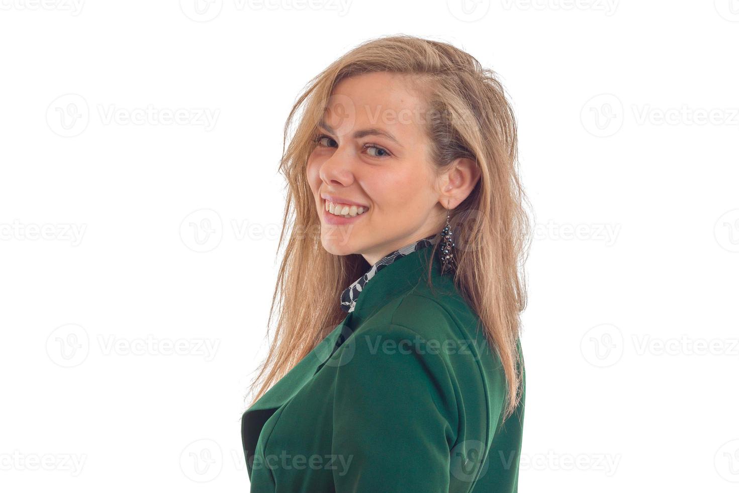 retrato de uma bela jovem loira em uma jaqueta verde que fica de lado parece reto e sorridente foto