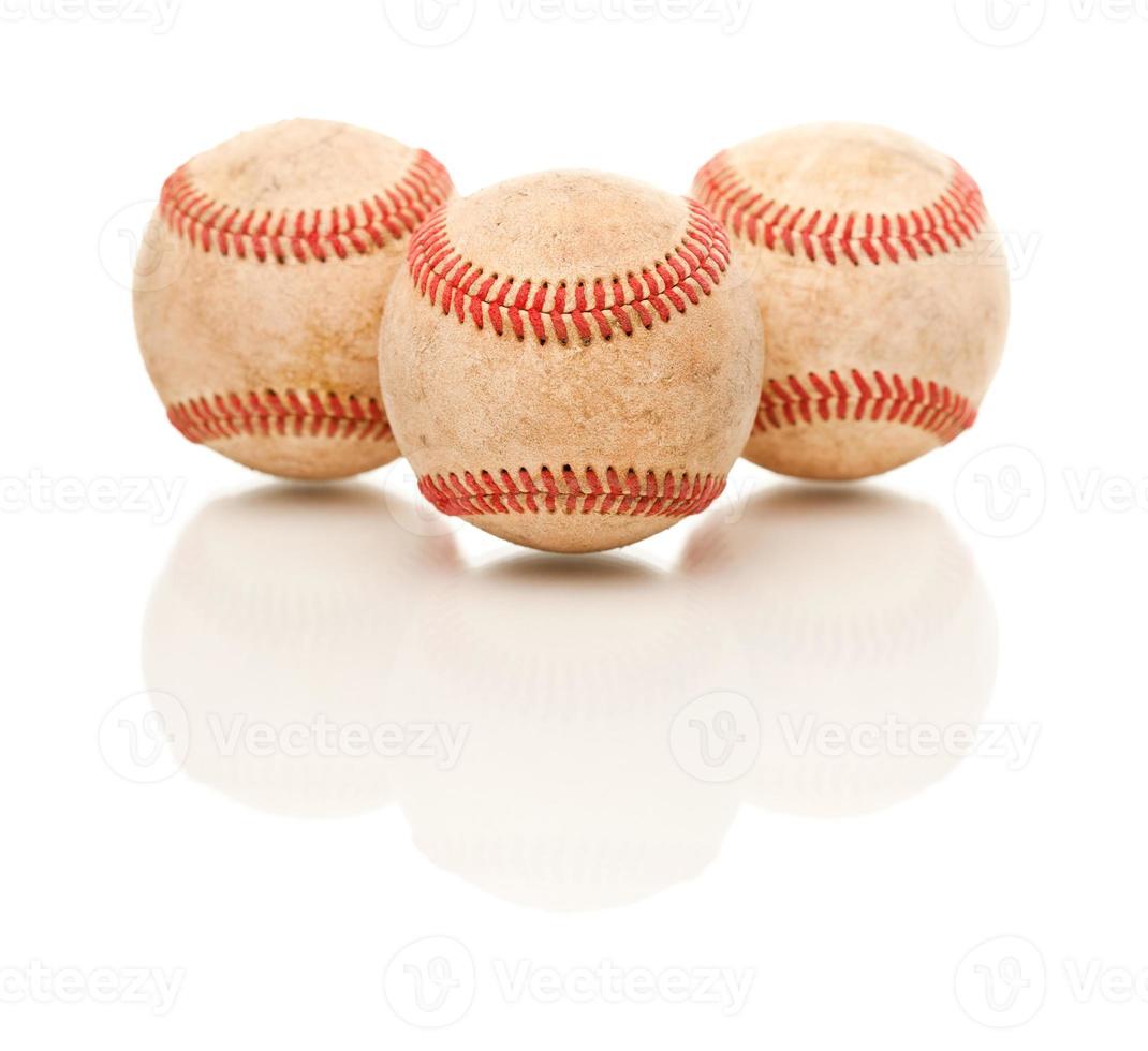 três bolas de beisebol isoladas em branco reflexivo foto