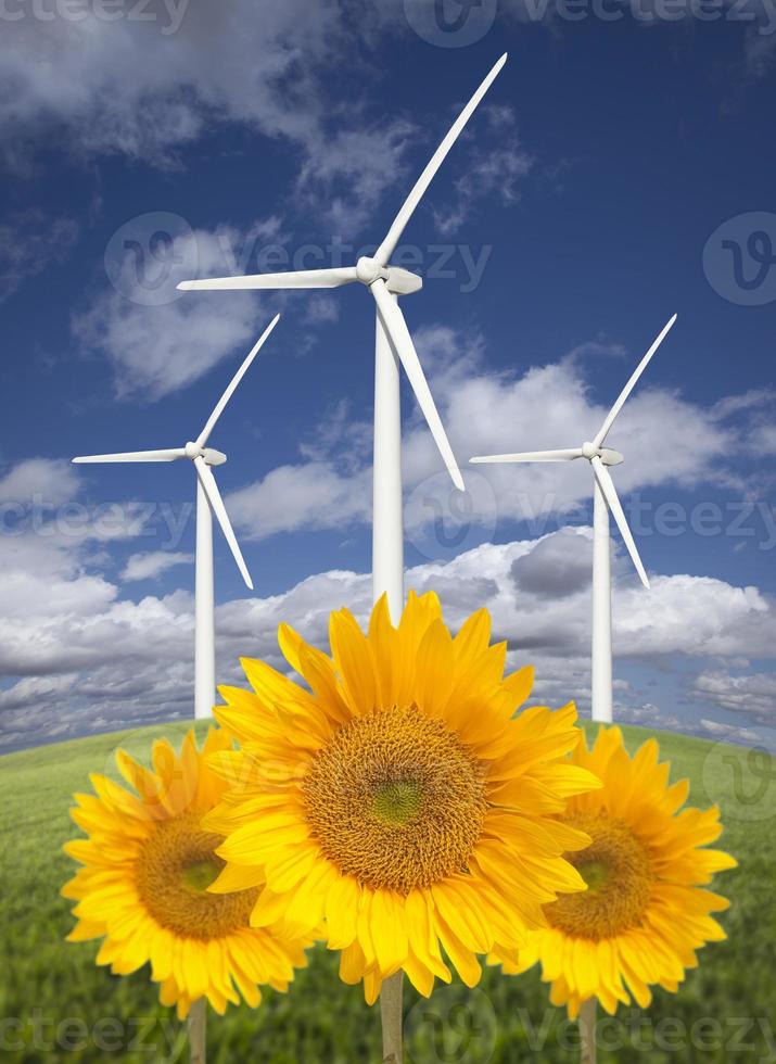 turbinas eólicas contra céu dramático com girassóis brilhantes foto