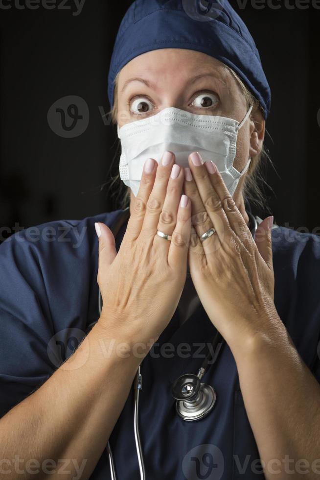 médica chocada com as mãos na frente da boca foto