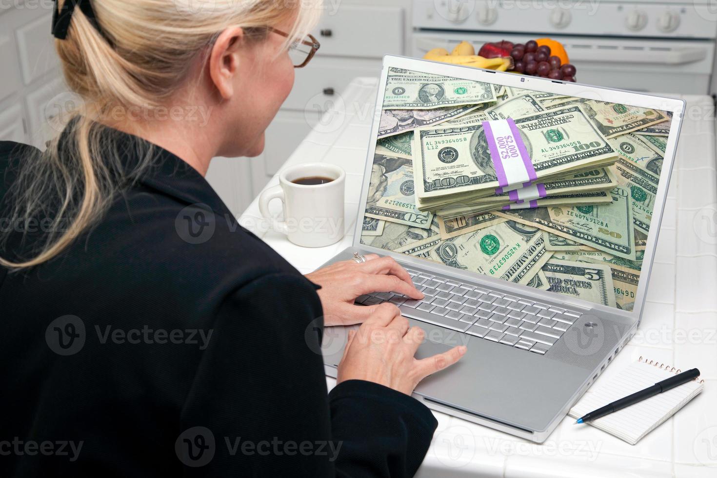 mulher na cozinha usando laptop - dinheiro foto