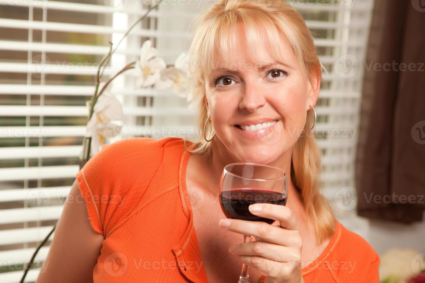 loira atraente com um copo de vinho foto