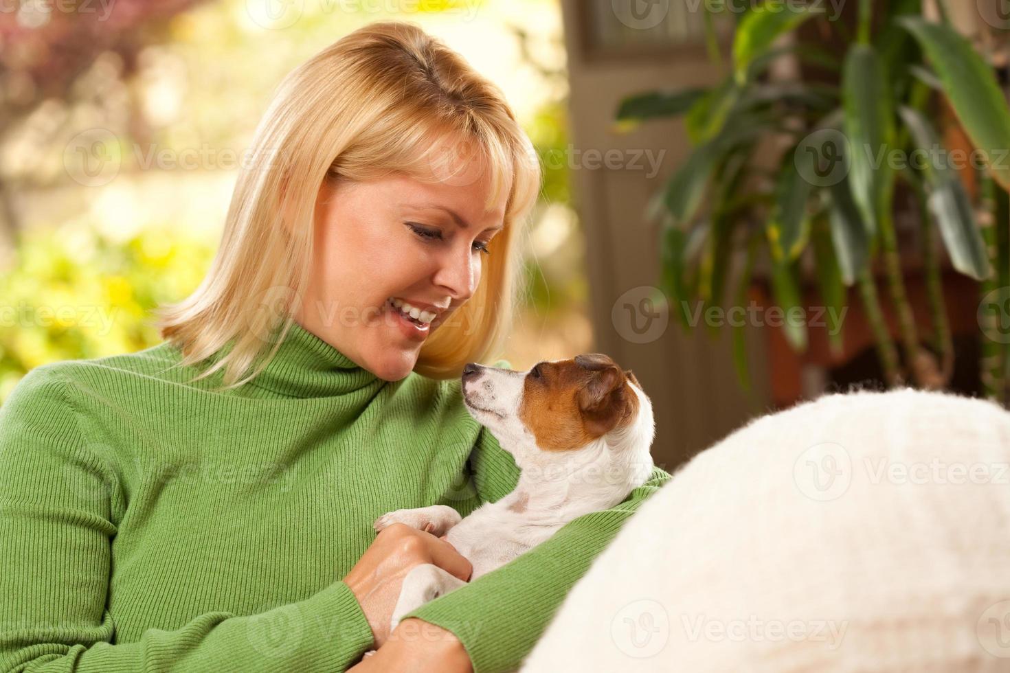 mulher e cachorrinho aproveitando o dia no sofá foto