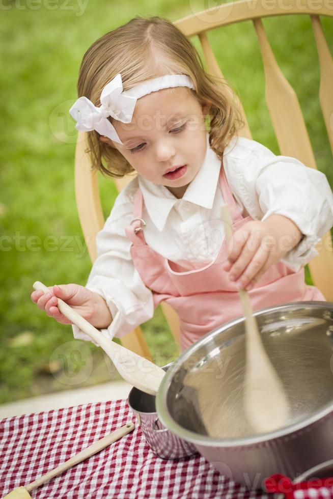 adorável menina jogando chef de cozinha foto