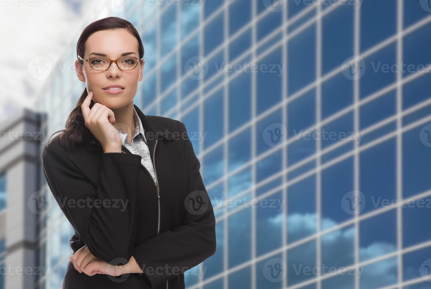 mulher atraente e confiante de raça mista em frente ao prédio corporativo foto