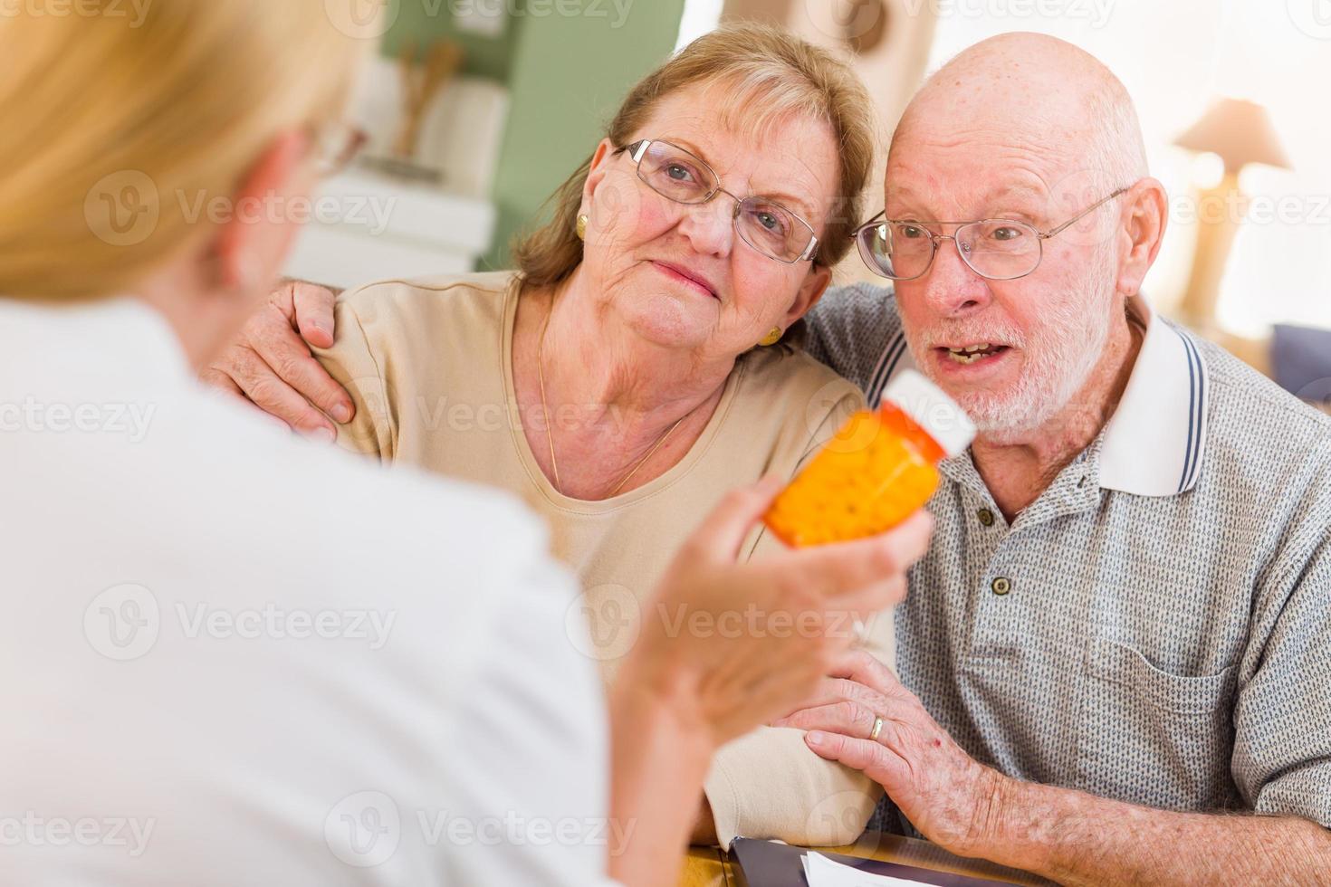 médico ou enfermeiro explicando medicamentos prescritos para casal adulto sênior foto