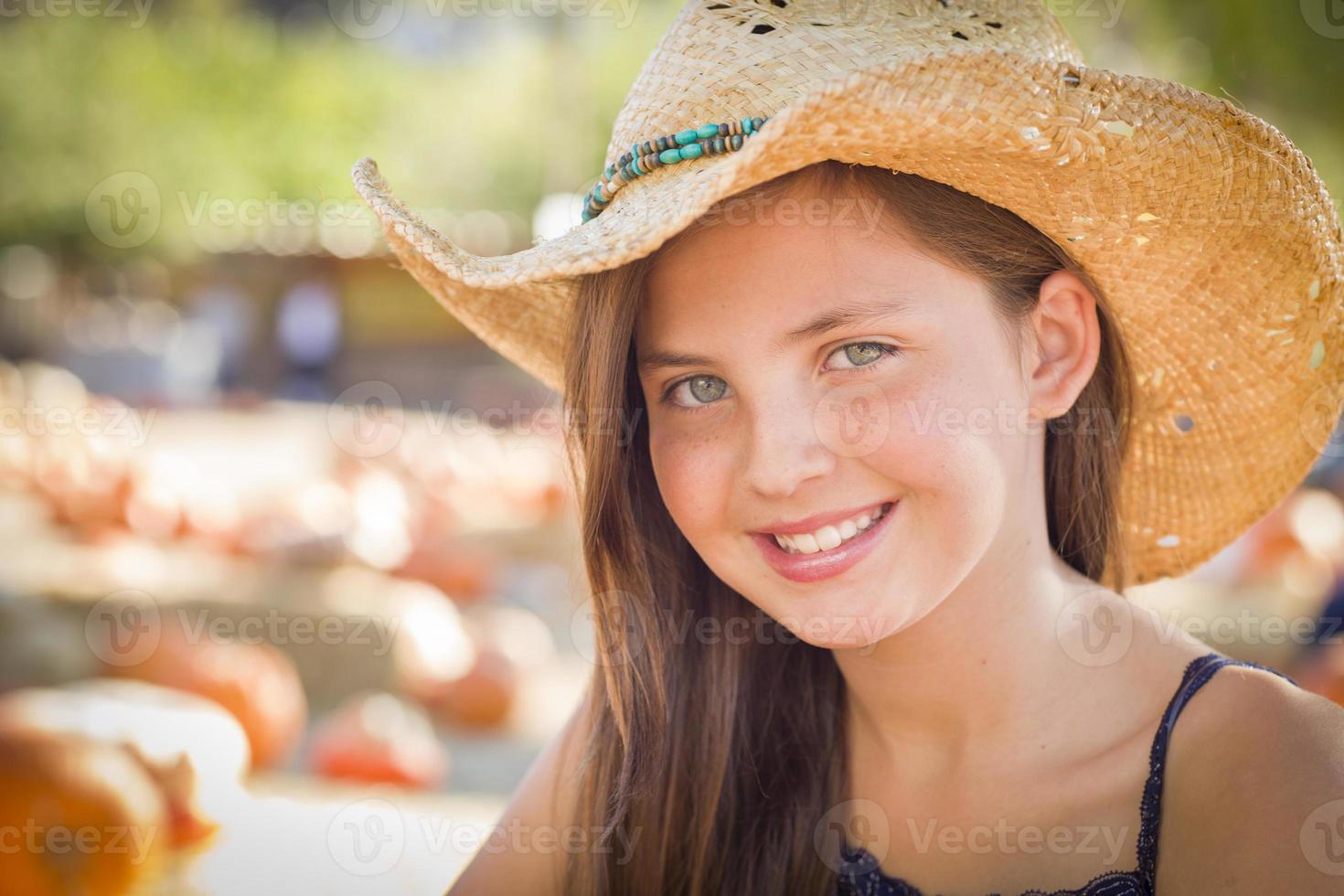 retrato de menina pré-adolescente usando chapéu de cowboy no canteiro de abóboras foto