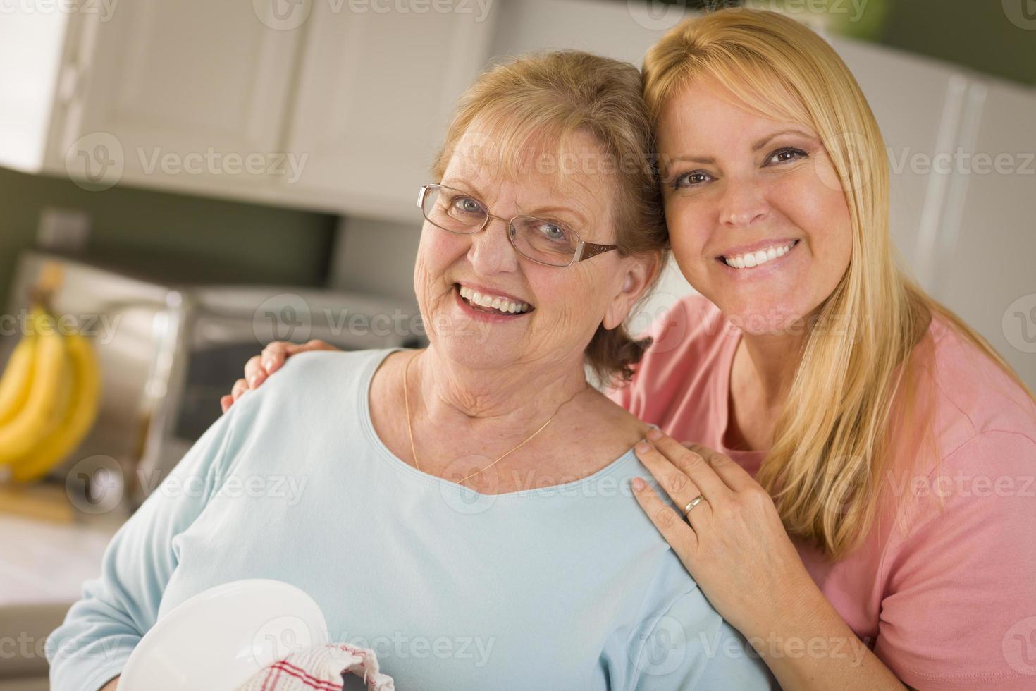 mulher adulta sênior e jovem filha retrato na cozinha foto