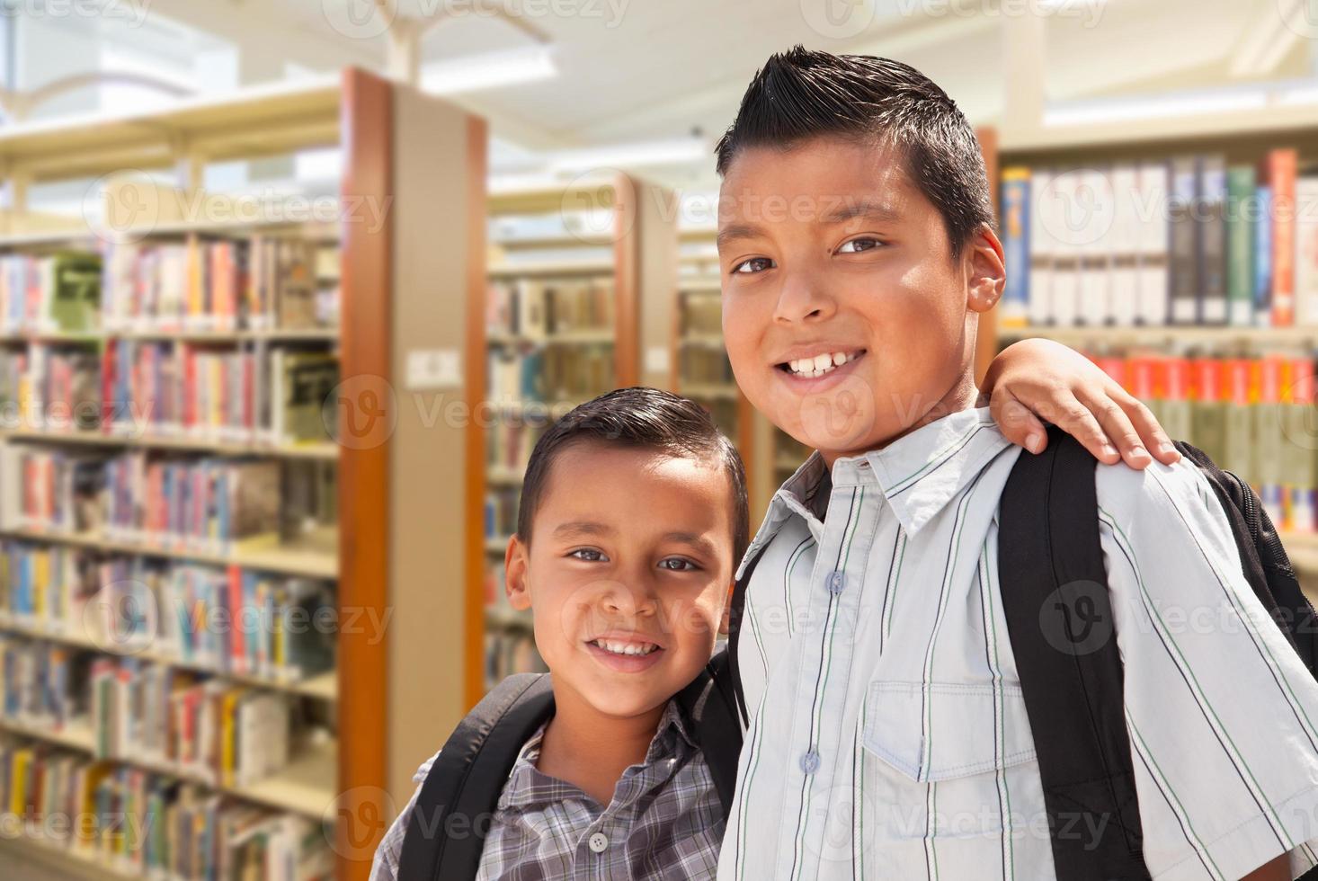 irmãos jovens estudantes hispânicos na biblioteca foto