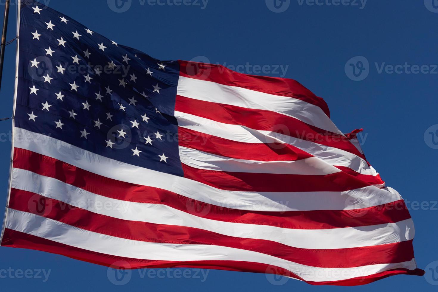 bandeira americana balançando ao vento contra um céu azul profundo foto