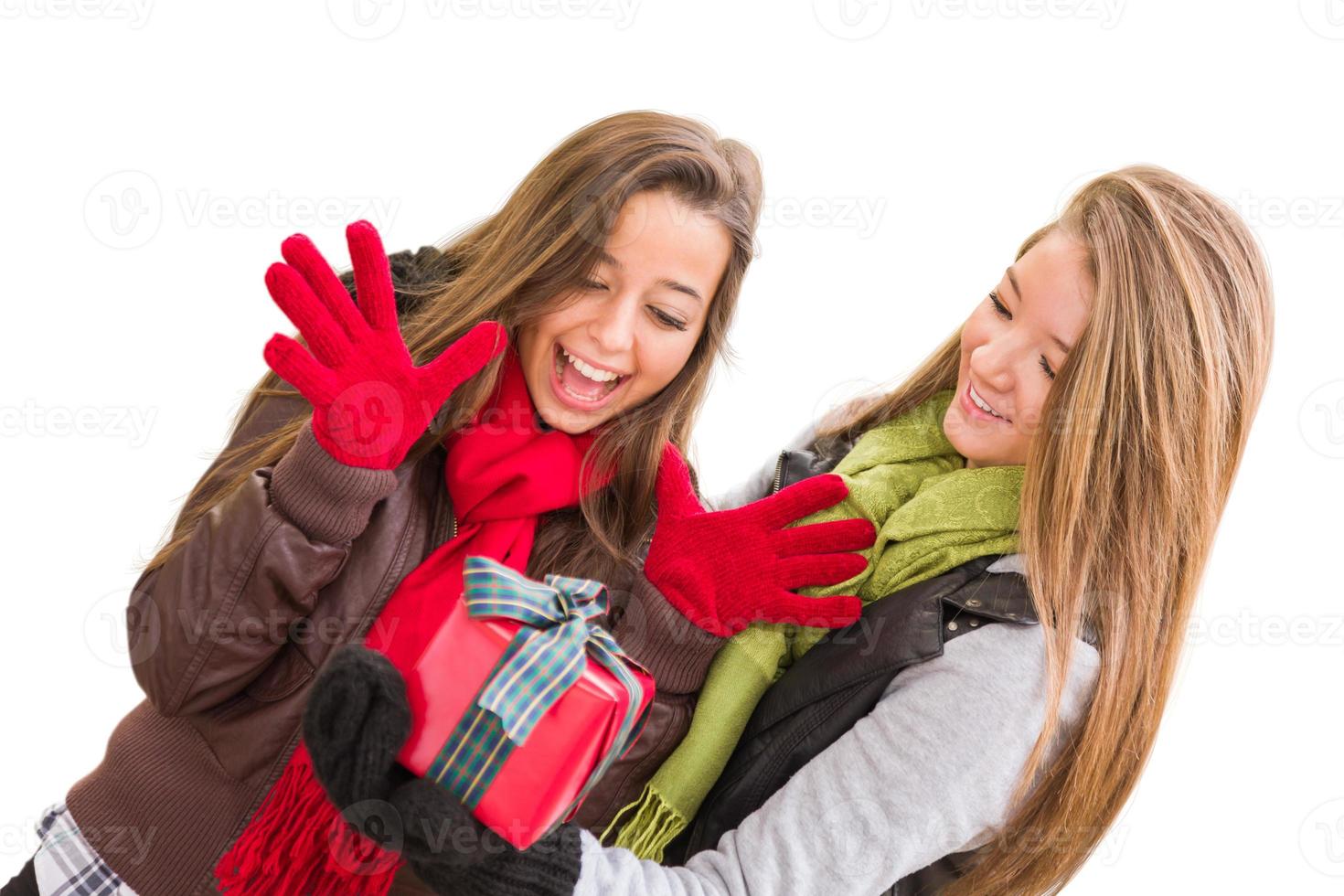 fêmeas adultas jovens de raça mista segurando um presente de natal isolado em um fundo branco. foto