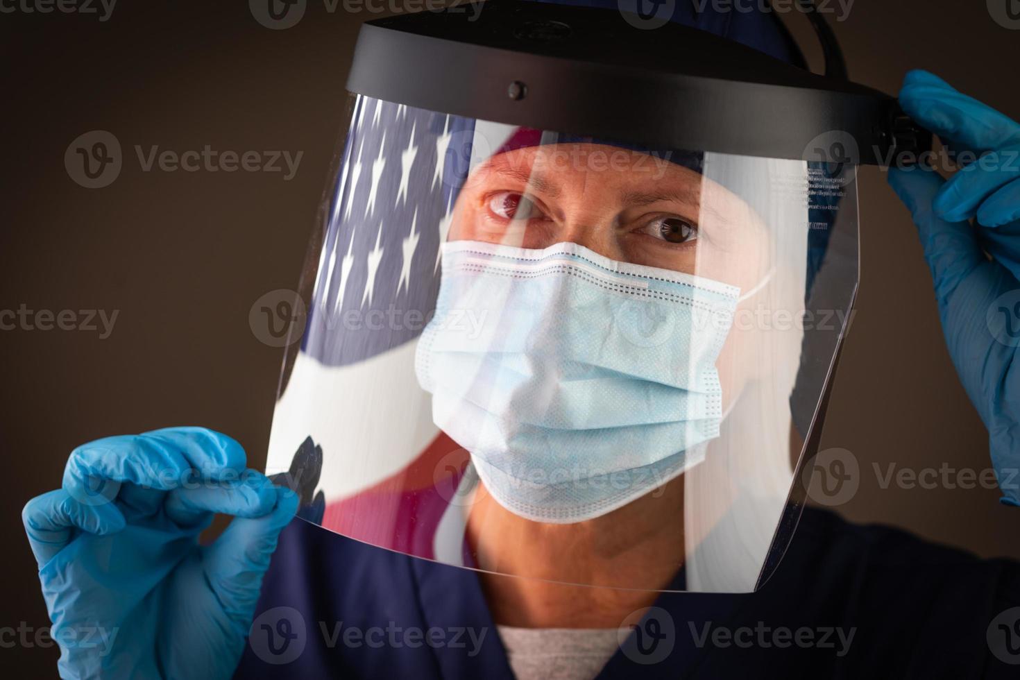 bandeira americana refletindo sobre a trabalhadora médica usando escudo e máscara protetora foto