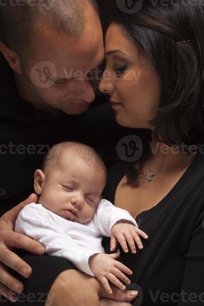 família jovem de raça mista com bebê recém-nascido foto