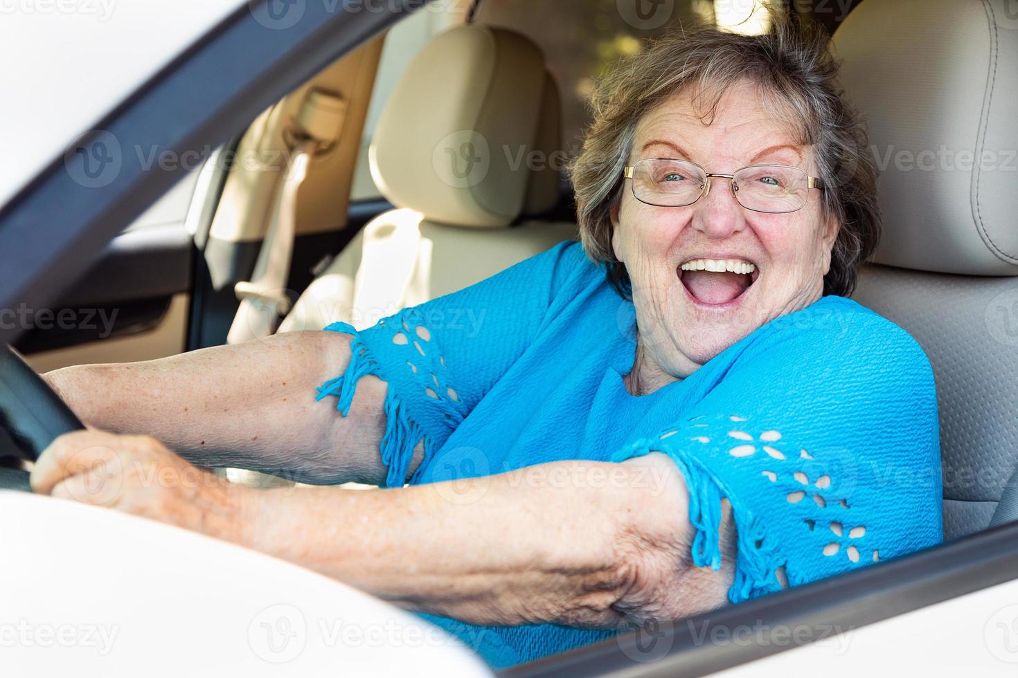 mulher sênior feliz dirigindo carro novo foto