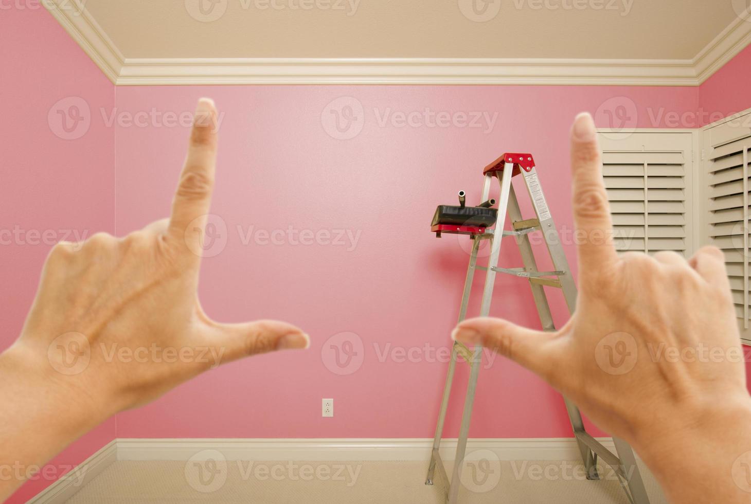 mãos emoldurando o interior da parede pintada de rosa foto