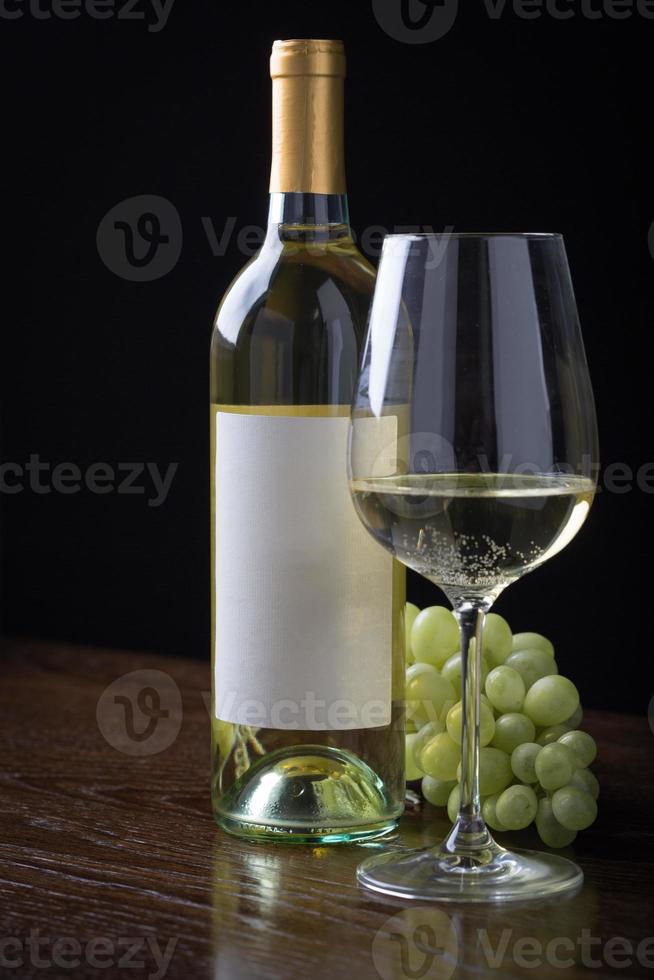 copo de vinho e garrafa com rótulo em branco pronto para gráfico e texto. foto
