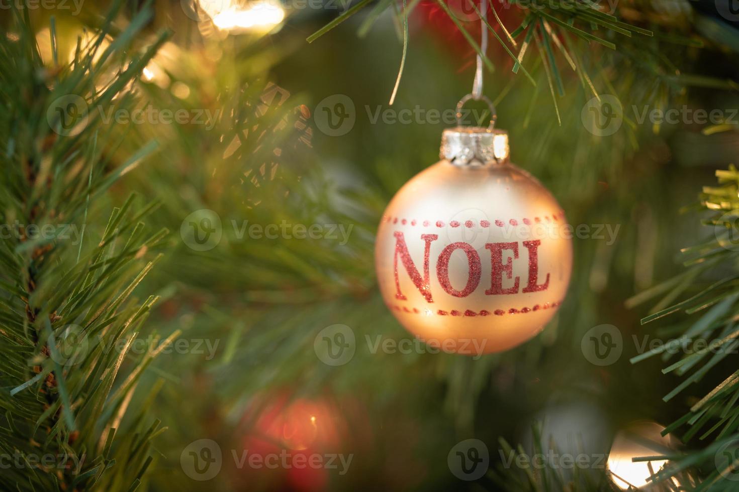 noel escrito no enfeite de natal pendurado na árvore foto