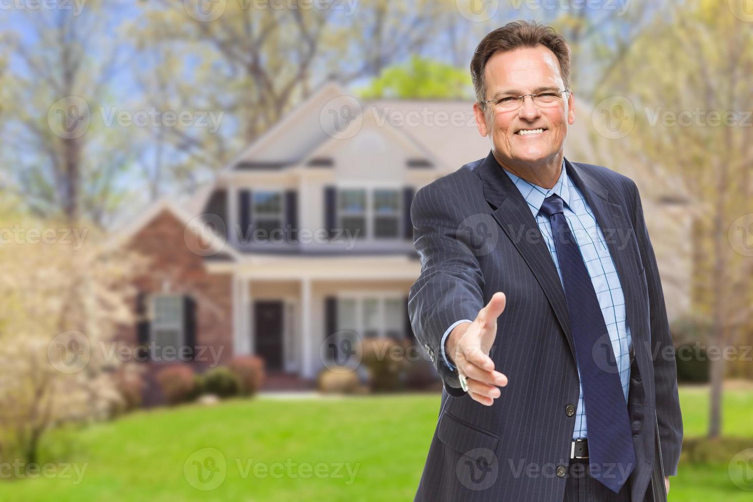 agente masculino pegando aperto de mão na frente de casa foto