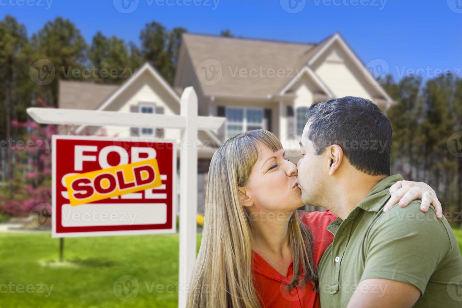 casal em frente a placa de imóveis e casa foto