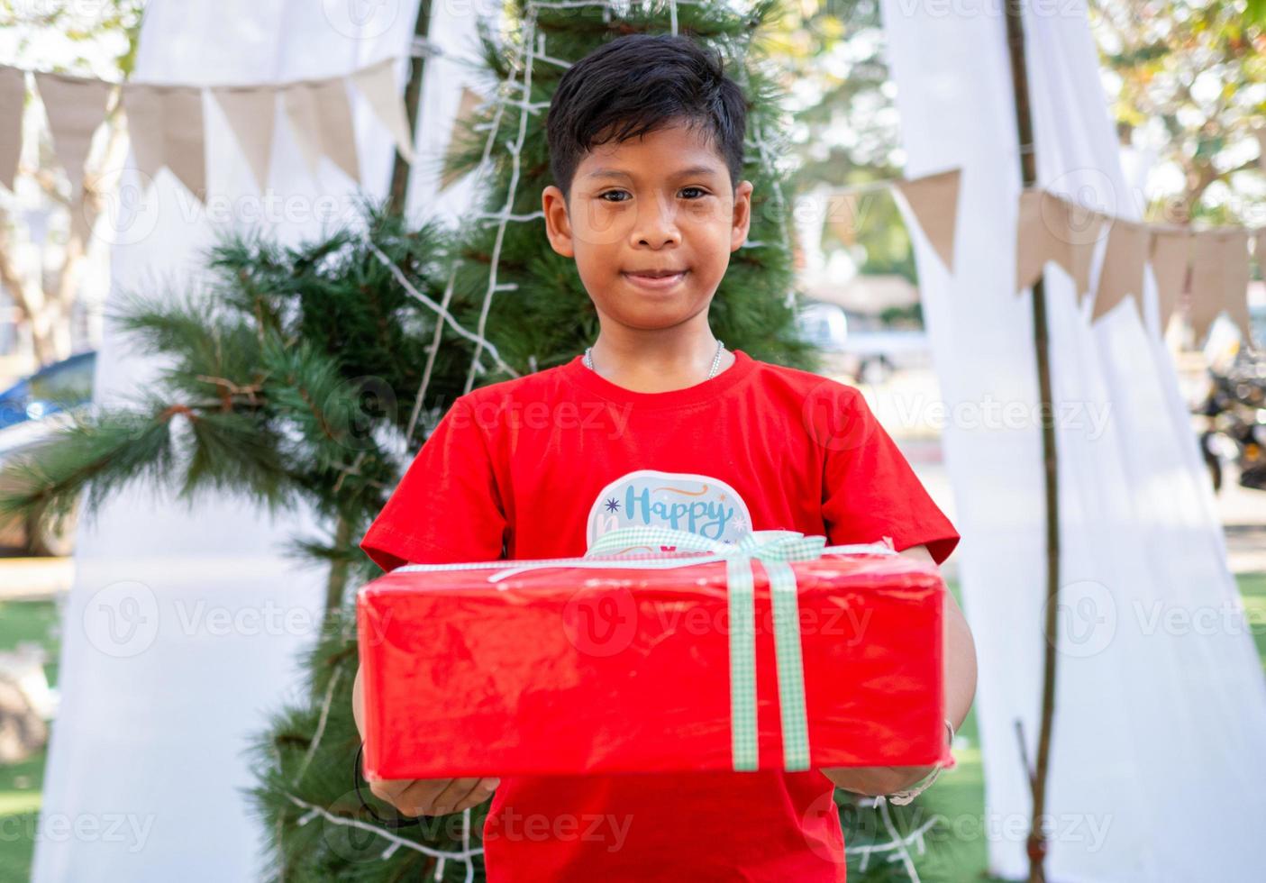 menino segurando presentes no festival de celebration.christmas de natal. foto