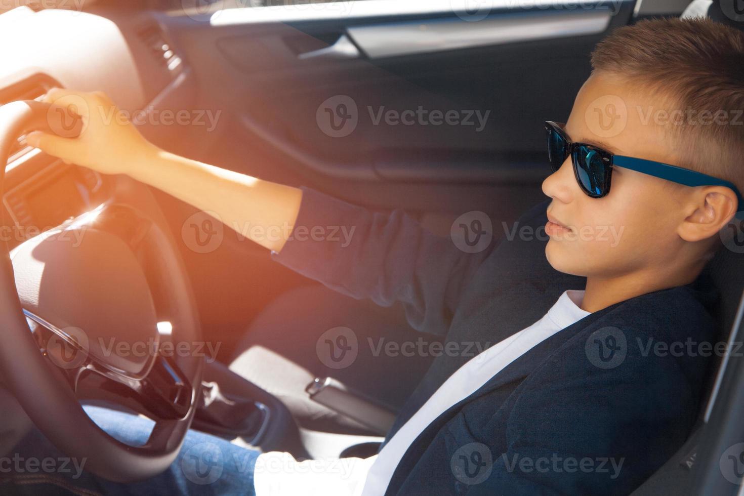 menino dirigindo um carro em óculos foto