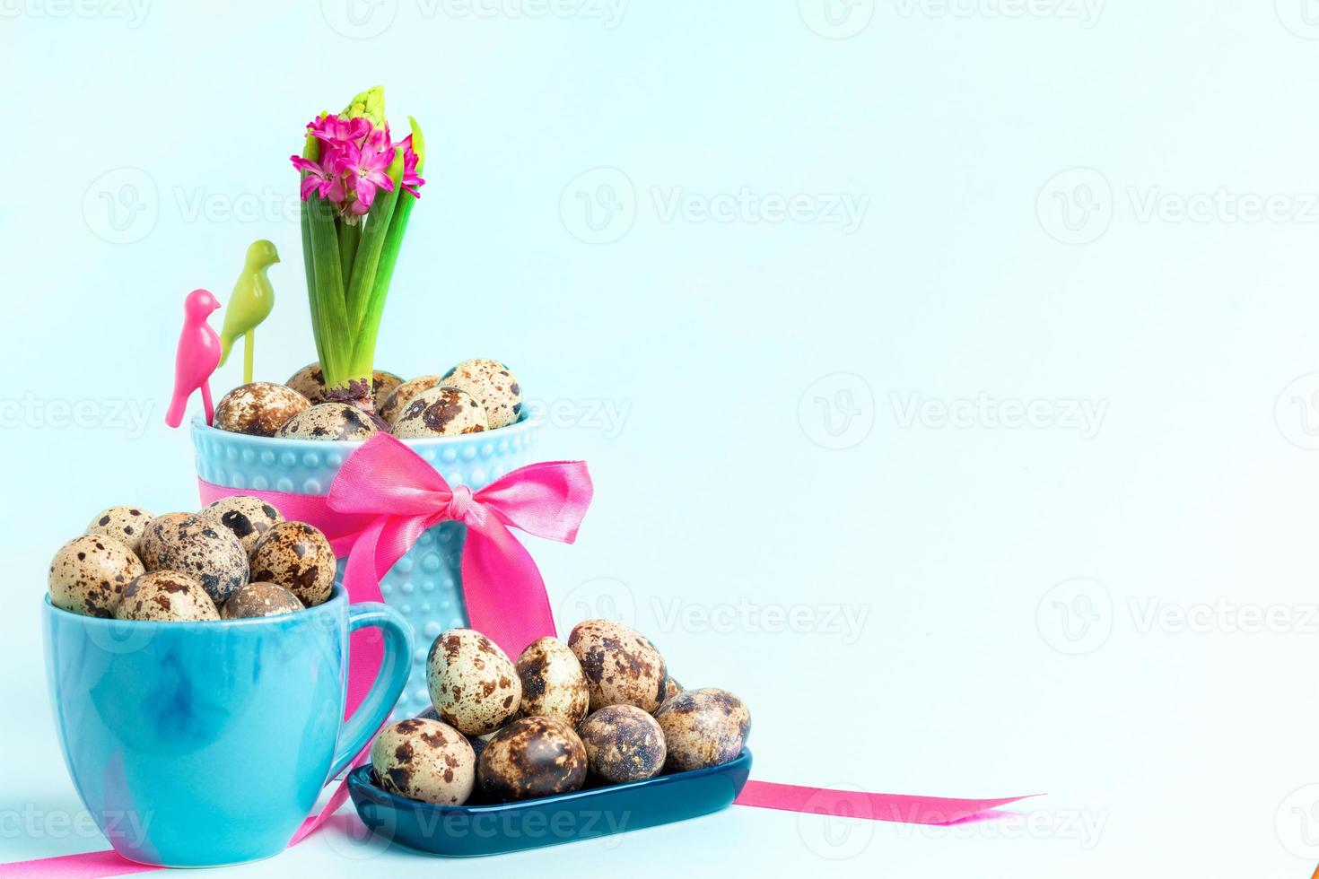 monte de ovos de codorna, jacinto rosa em vaso de flores decorado por fita rosa em azul pastel. copie o espaço. foto