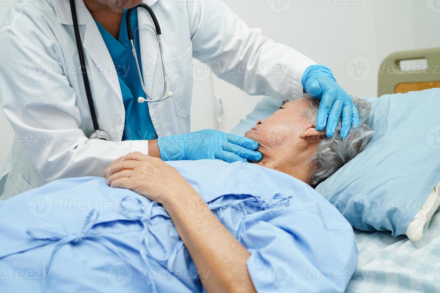médico cuidando, ajudando e incentivando a paciente idosa asiática idosa no hospital clínico. foto