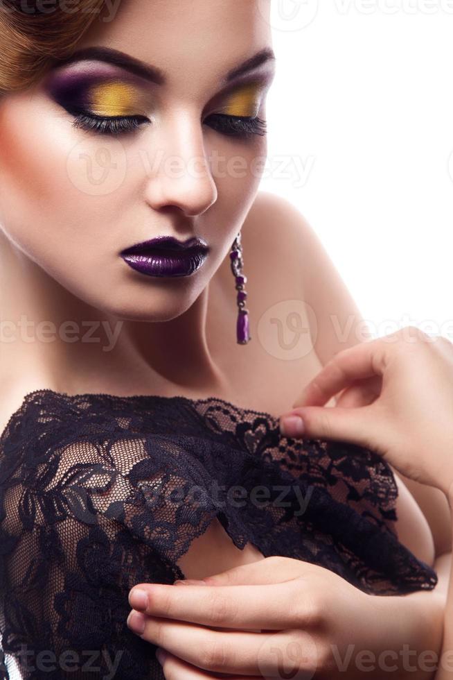 modelo encantador com olhos fechados e maquiagem violeta em fundo branco foto