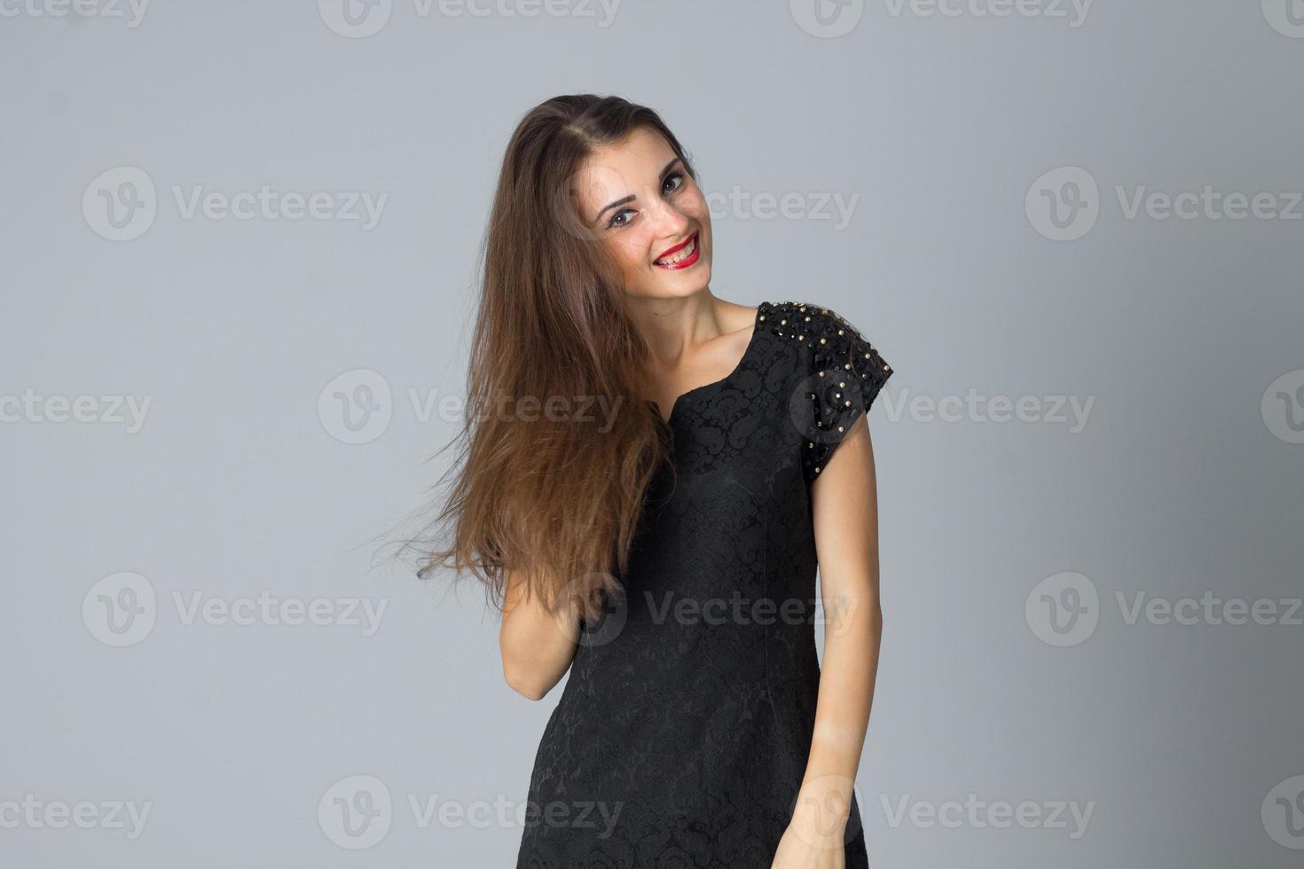 garota de vestido preto posando no estúdio foto