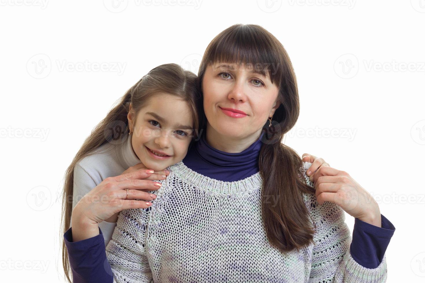 casal de mãe com sua filha abraçando e sorrindo na câmera foto