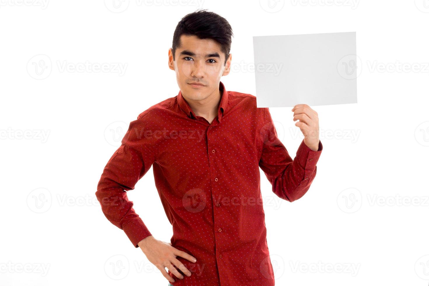 cara jovem elegante na camisa vermelha com cartaz vazio nas mãos posando isolado no fundo branco foto