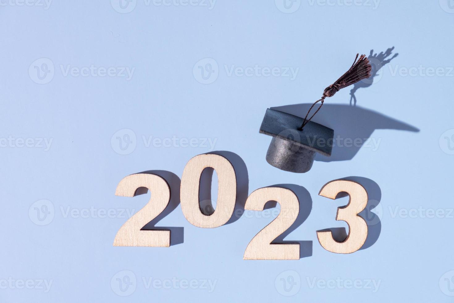 conceito de classe de 2023. números 2023 com boné graduado preto sobre fundo colorido foto