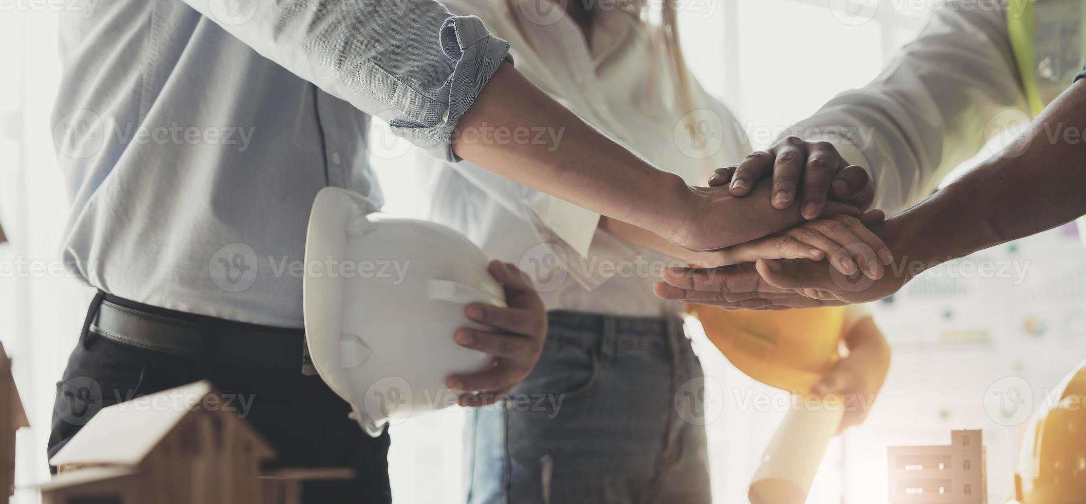 empresários e engenheiros dão as mãos para construir projetos de sucesso. conceito de trabalho em equipe. foto