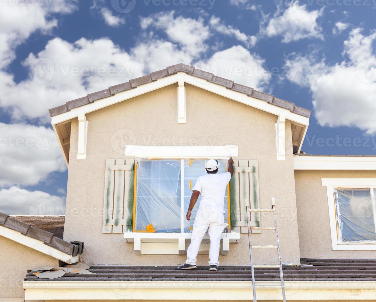 pintor de casa pintando a guarnição e persianas de casa foto